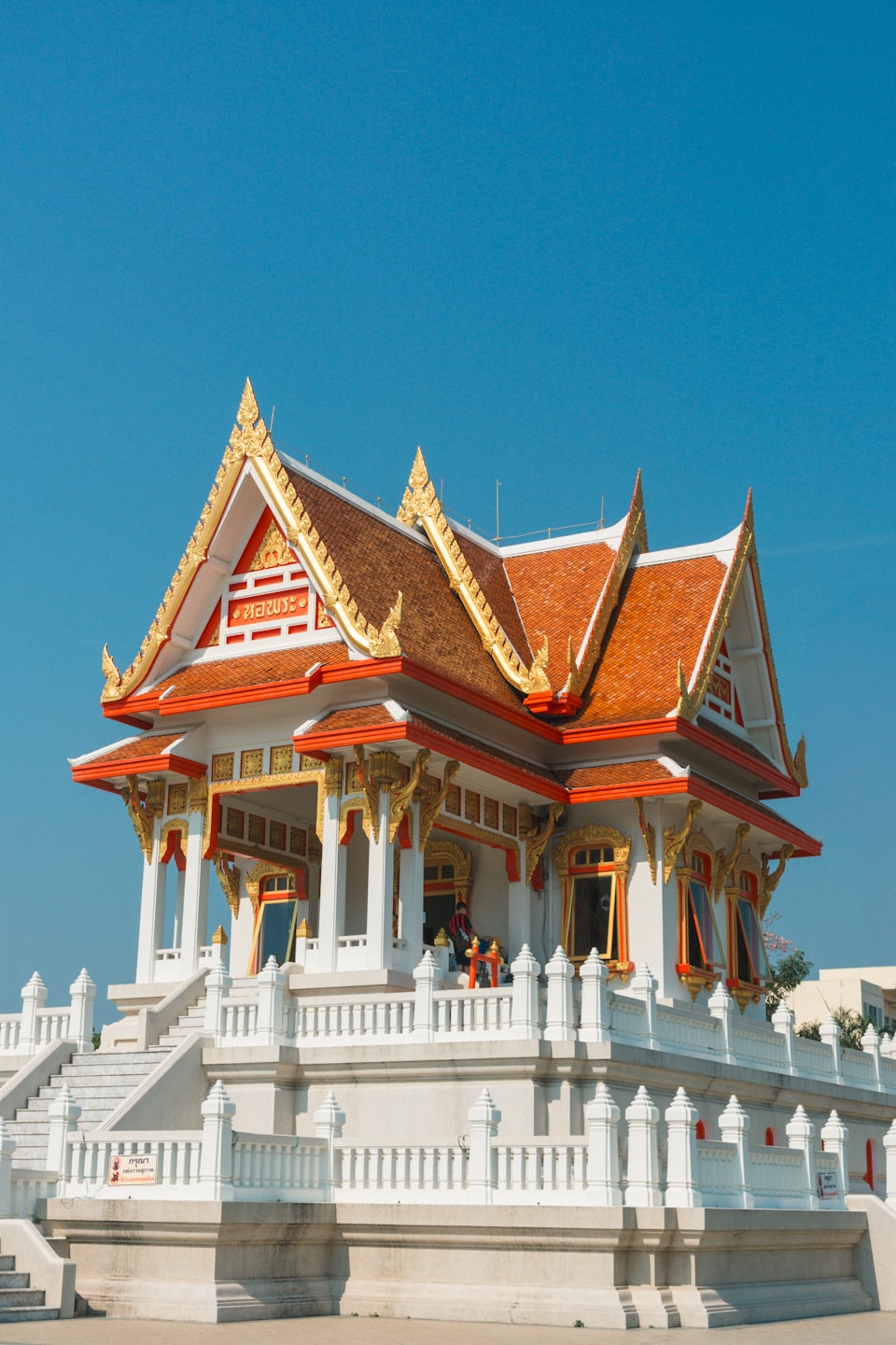 Ornate Thai temple with gold trim and tiled roofs.